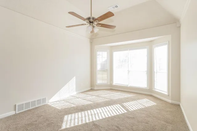 an empty room with fan and windows