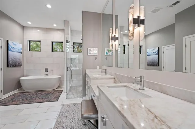 a spacious bathroom with a granite countertop sink mirror and bathtub