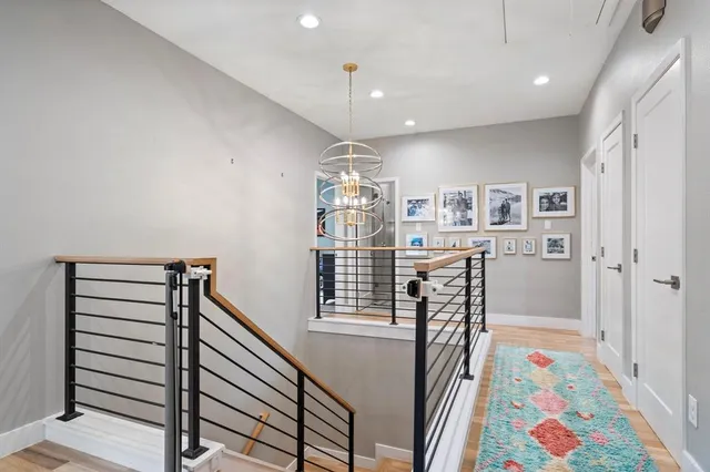 a view of a hallway with wooden floor and furniture