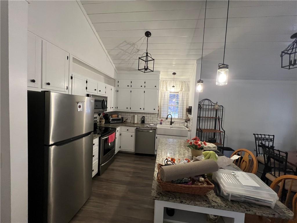 40 Chestatee Springs Road Dahlonega, GA 30533 - Photo 26 of 42 a kitchen with stainless steel appliances kitchen island granite countertop a refrigerator a stove a sink dishwasher a dining table and chairs with wooden floor