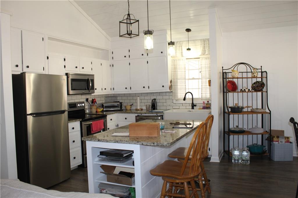 40 Chestatee Springs Road Dahlonega, GA 30533 - Photo 4 of 43 a kitchen with stainless steel appliances granite countertop a refrigerator a stove and a dining table