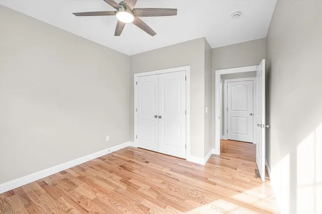 a view of a room with wooden floor and ceiling fan
