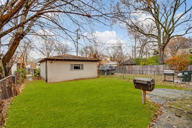 a view of backyard of house with wooden fence