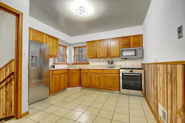 a kitchen with stainless steel appliances granite countertop a refrigerator and a stove top oven