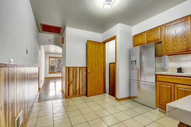 a view of a refrigerator in kitchen and a windows