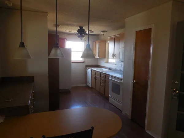 a kitchen with kitchen island a counter top space a sink a refrigerator and window