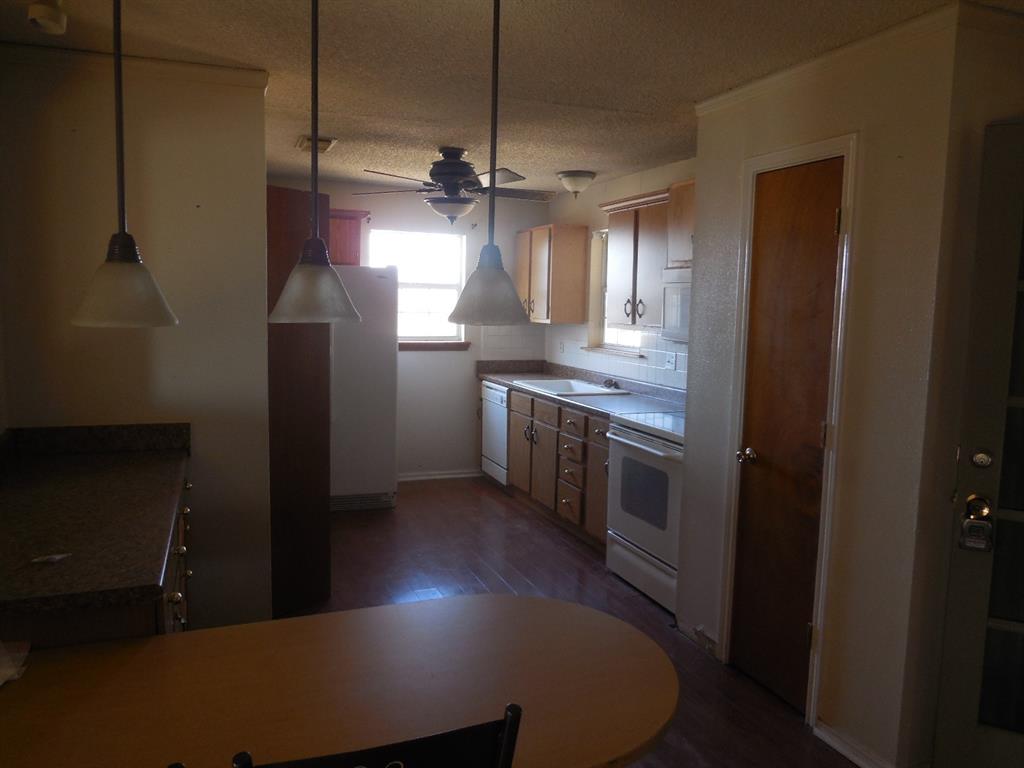 6008 Interstate 20 Ranger, TX 76470 - Photo 3 of 15 a kitchen with kitchen island a counter top space a sink a refrigerator and window