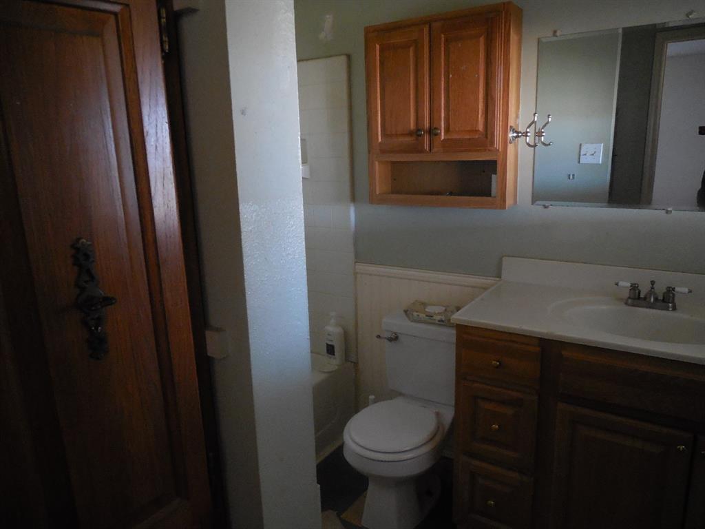 6008 Interstate 20 Ranger, TX 76470 - Photo 9 of 15 a bathroom with a granite countertop toilet sink and mirror