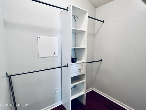 a view of walk in closet with empty racks