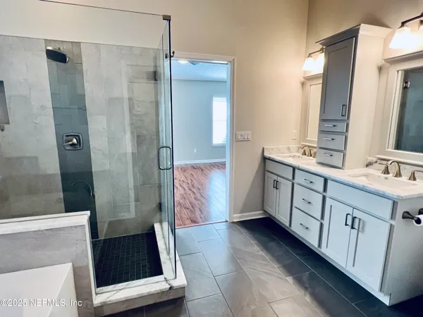 a bathroom with a double vanity sink mirror and shower
