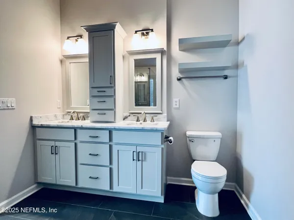 a bathroom with a toilet sink and mirror