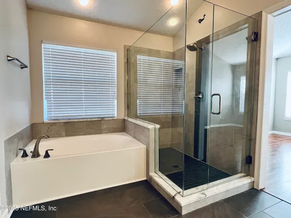 a bathroom with a tub a sink and shower