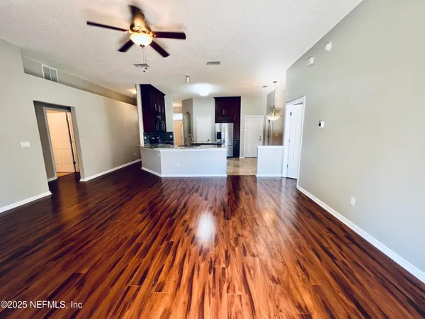 a view of empty room with wooden floor