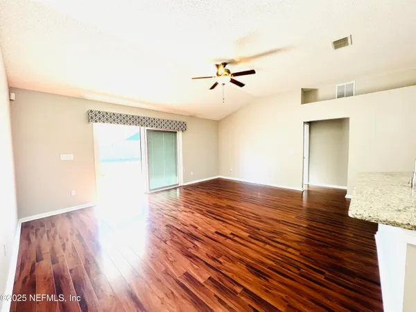 a view of empty room with wooden floor