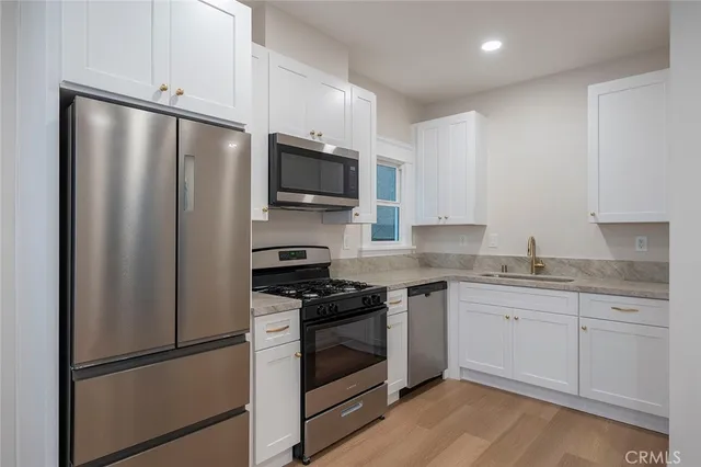 a kitchen with stainless steel appliances a refrigerator sink and microwave