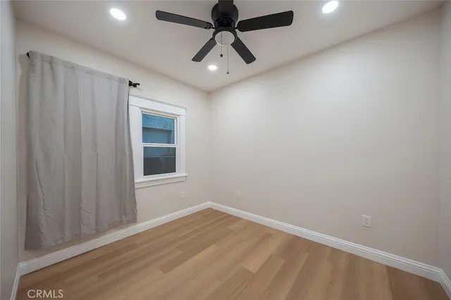 en empty room with ceiling fan and window
