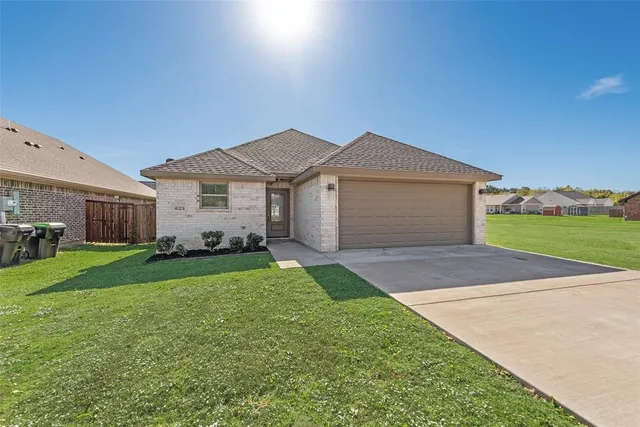 a front view of a house with a garden and yard
