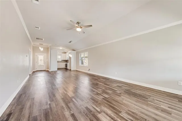 a view of empty room with wooden floor and window