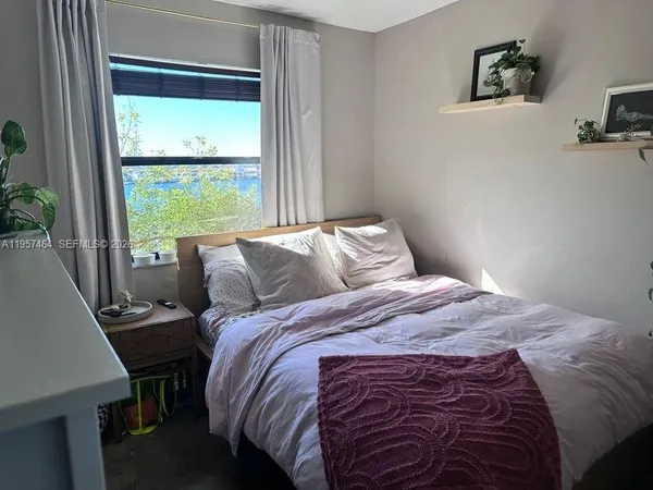 a bed sitting in a bedroom next to a window