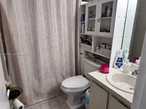 a bathroom with a sink a toilet and shower curtain