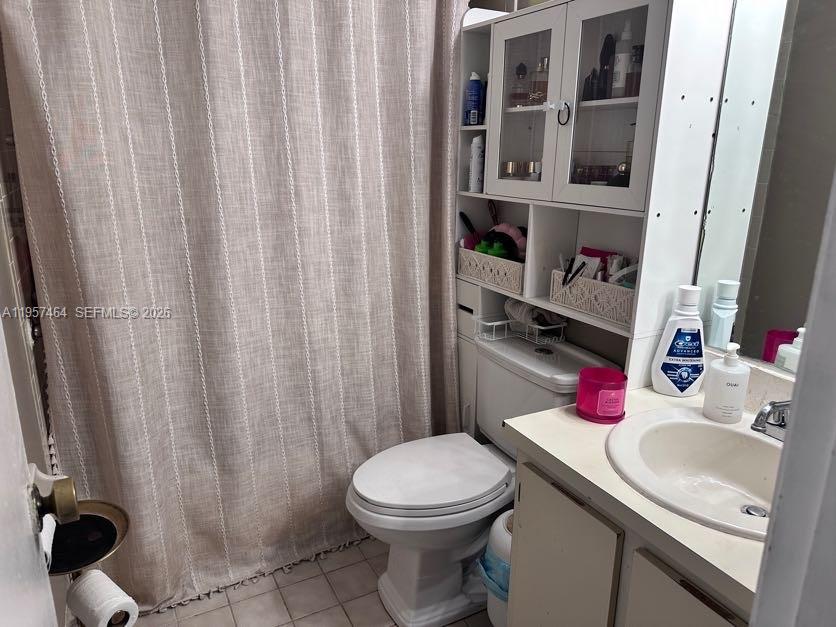 2480 West 67th Place, Unit 2312 Hialeah, FL 33016 - Photo 6 of 16 a bathroom with a sink a toilet and shower curtain