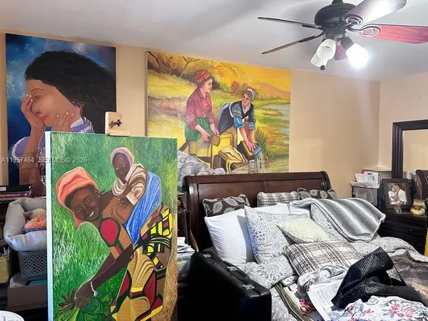 a bedroom with a bed and a painting on the wall
