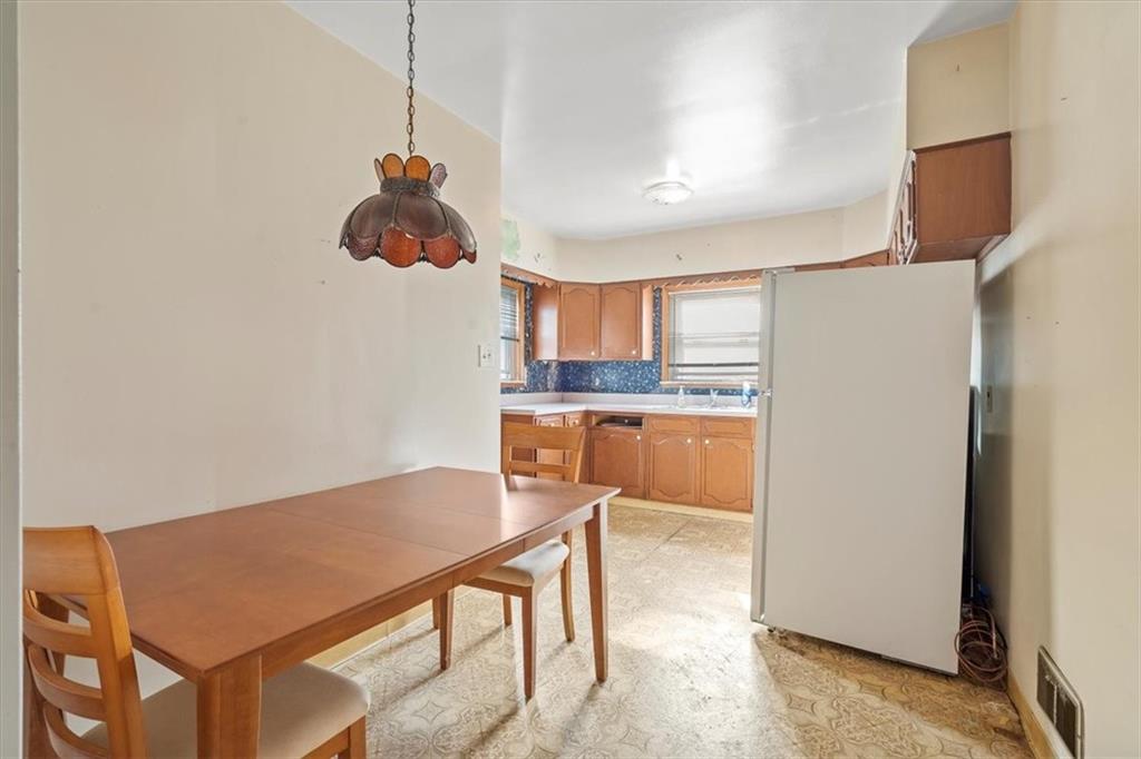 1105 15th Street McKees Rocks, PA 15136 - Photo 6 of 17 a kitchen with stainless steel appliances granite countertop a refrigerator a sink dishwasher a dining table and chairs with wooden floor