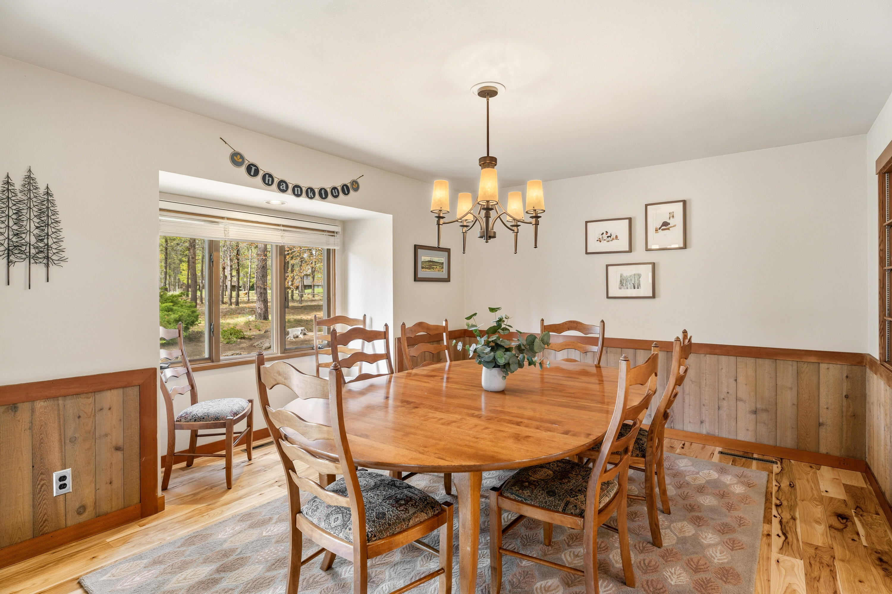 17866 Grouse Lane, Unit 3 Sunriver, OR 97707 - Photo 12 of 61 a view of a dining room and livingroom with furniture wooden floor a rug a painting and a chandelier