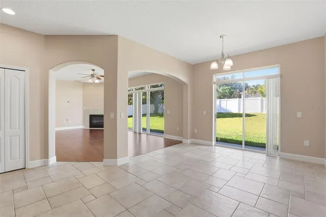 a view of an empty room with window and chandelier