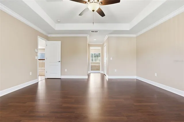 a view of an empty room with window and wooden floor