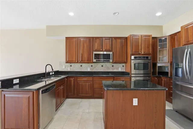 a kitchen with stainless steel appliances granite countertop a sink stove and refrigerator