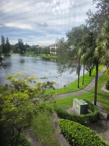 an aerial view of a house with green yard and lake view