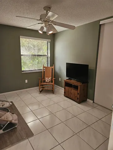 a living room with furniture a flat screen tv and a window