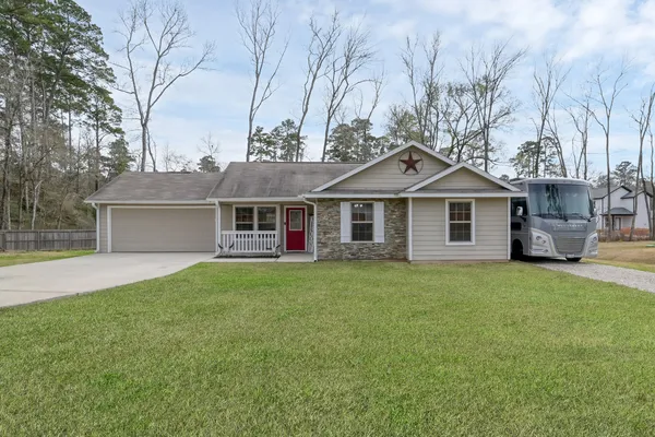 a front view of a house with a garden and yard