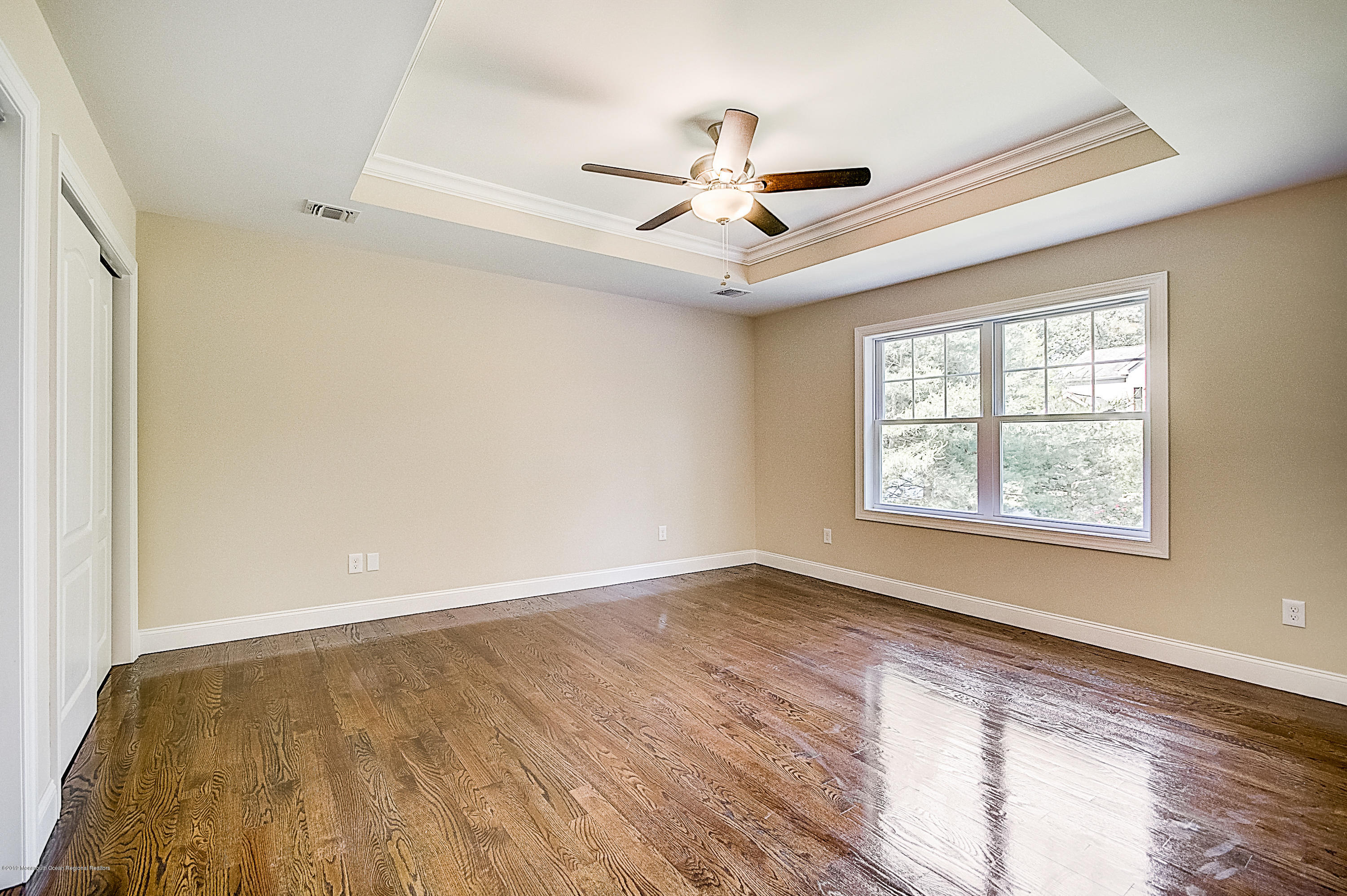 58 Tindall Road Middletown, NJ 07748 - Photo 54 of 74 a view of an empty room with wooden floor and a window