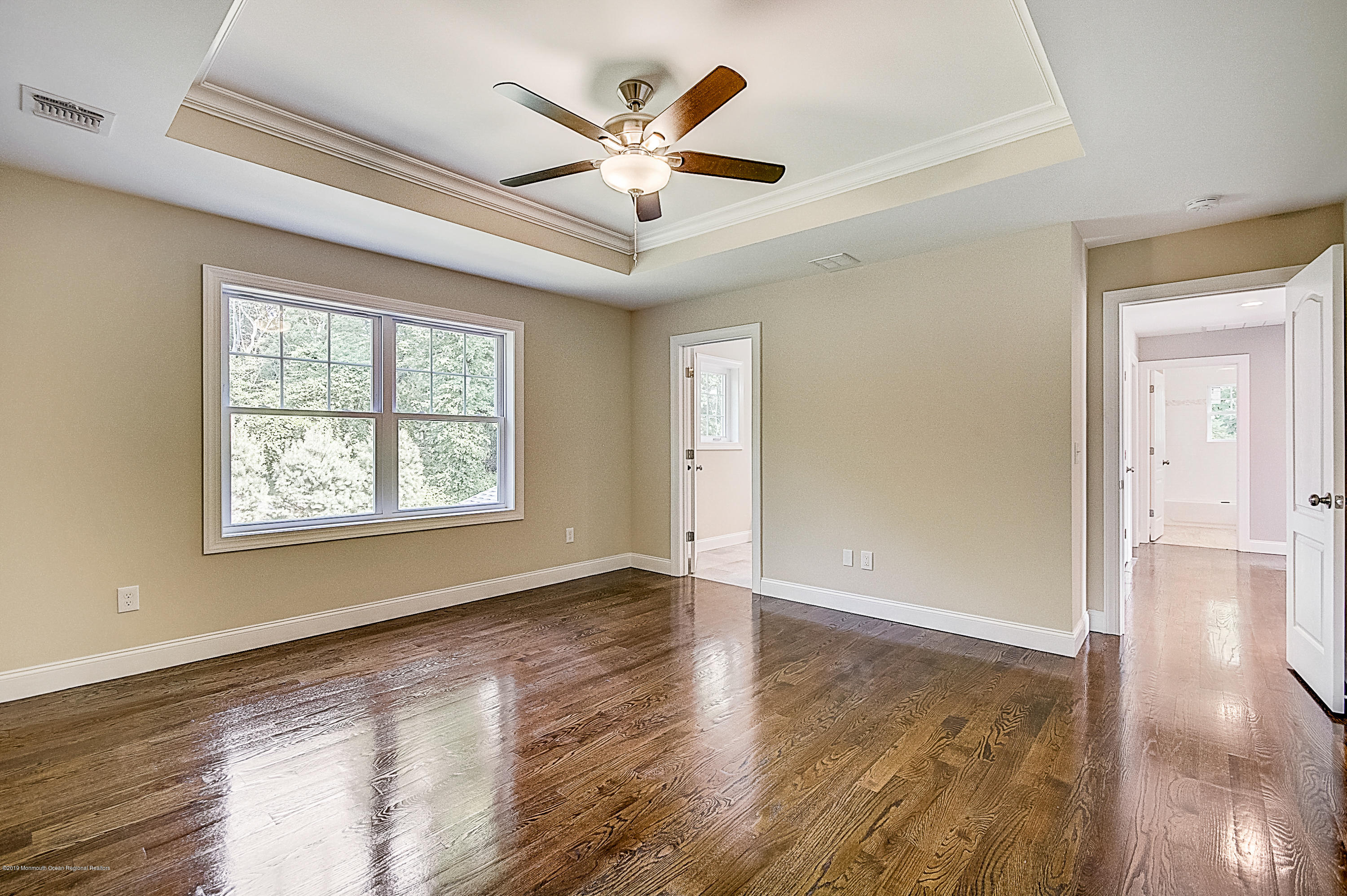 58 Tindall Road Middletown, NJ 07748 - Photo 55 of 74 a view of an empty room with window and wooden floor