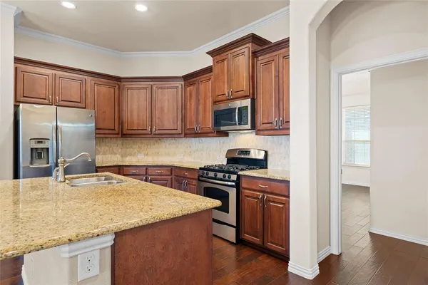 a kitchen with stainless steel appliances granite countertop a sink stove and refrigerator