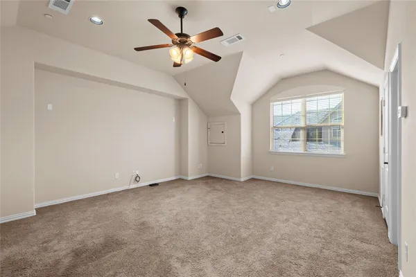 an empty room with windows and fan