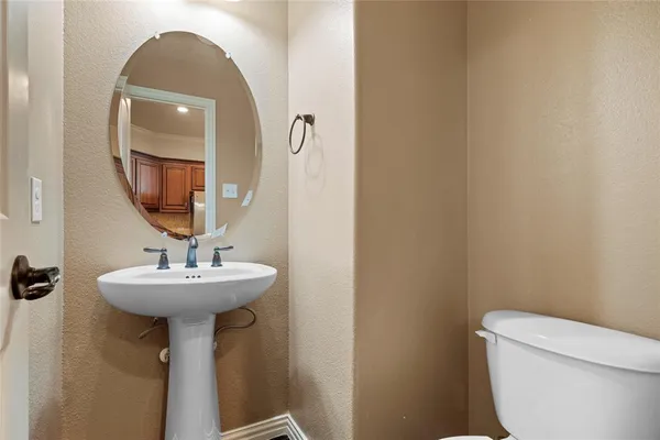 a bathroom with a sink a toilet and mirror