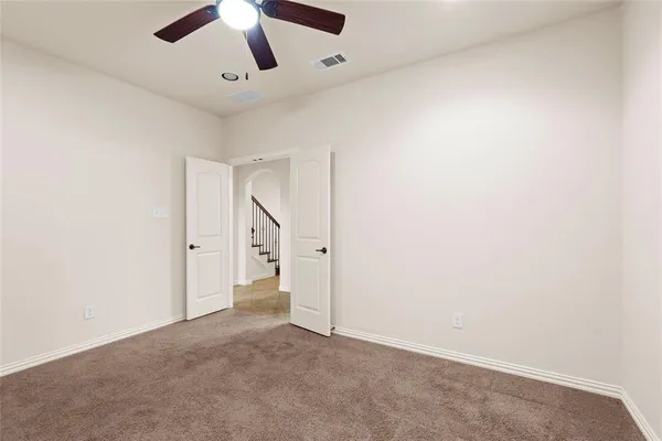 an empty room with chandelier fan