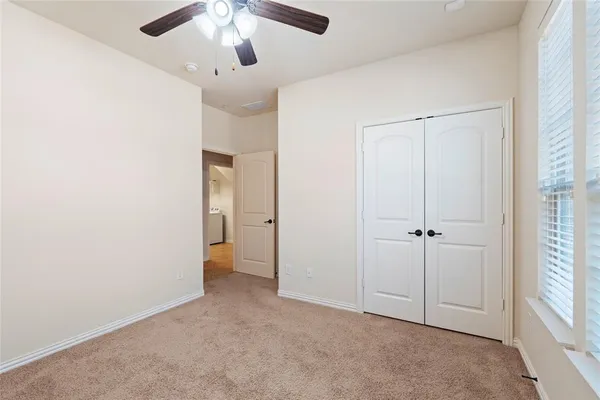 a view of an empty room and chandelier fan
