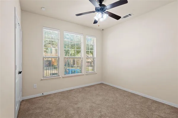an empty room with a window and a fan