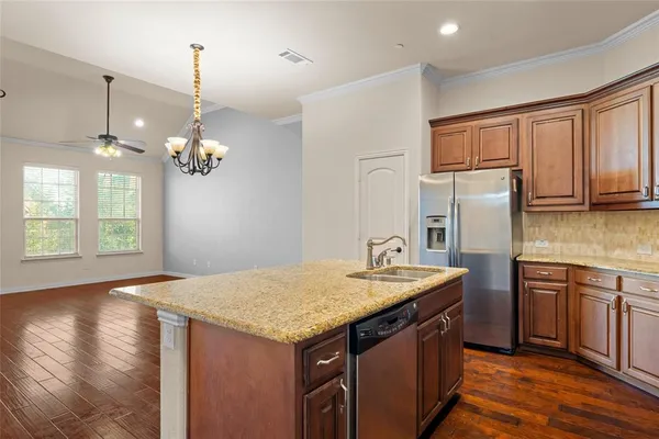 a kitchen with stainless steel appliances granite countertop a sink a refrigerator and a stove