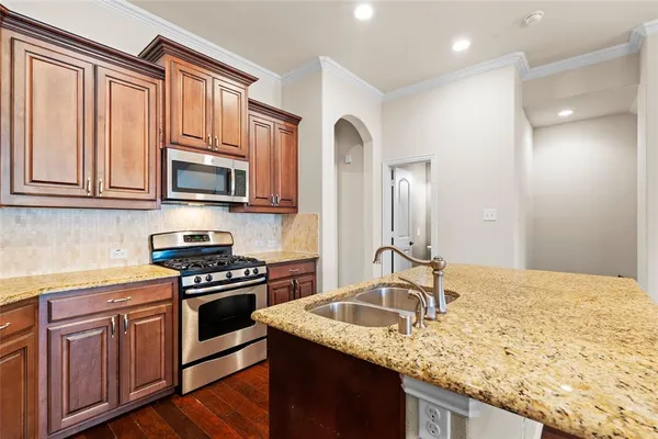 a kitchen with stainless steel appliances granite countertop a sink stove and refrigerator