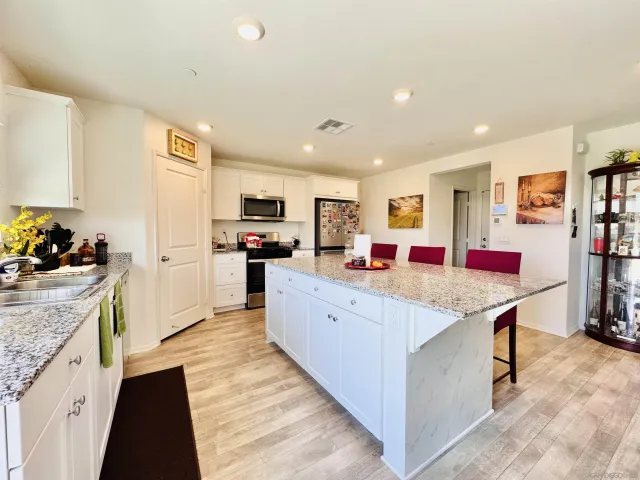 a large kitchen with stainless steel appliances kitchen island granite countertop a large counter top and a stove