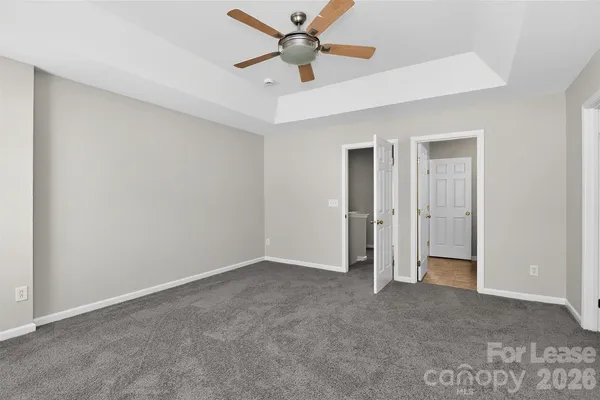 an empty room with closet and a ceiling fan