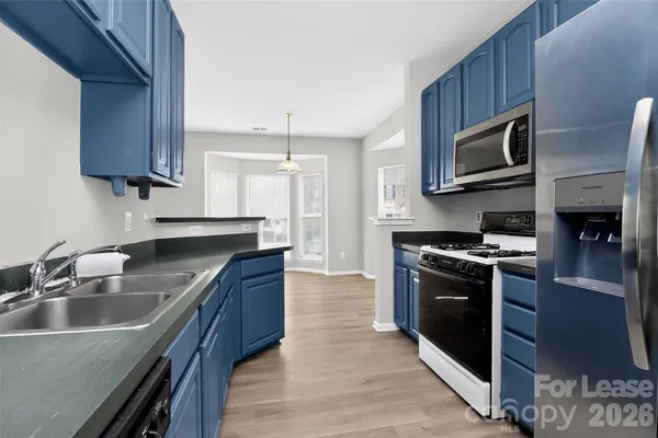 a kitchen with stainless steel appliances granite countertop a sink stove and microwave