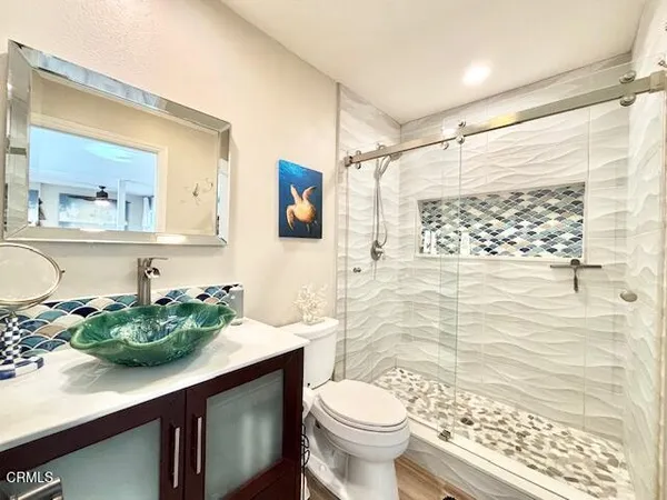 a bathroom with a sink a toilet and shower
