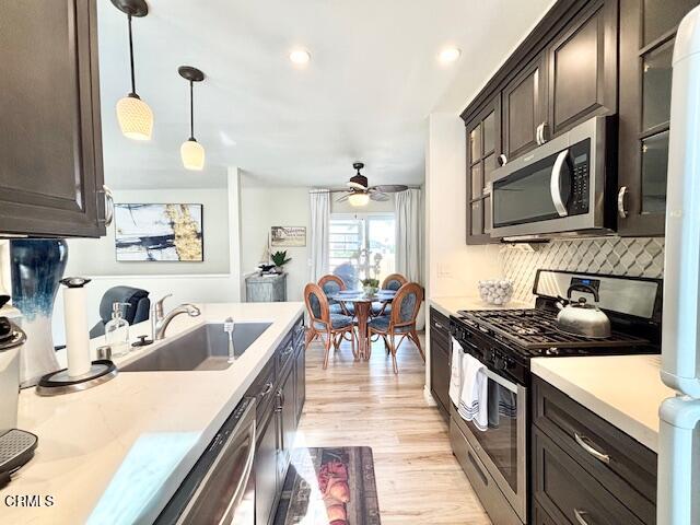 3721 Sunset Lane Oxnard, CA 93035 - Photo 5 of 26 a kitchen with stainless steel appliances kitchen island granite countertop a stove a sink a dining table and chairs with wooden floor