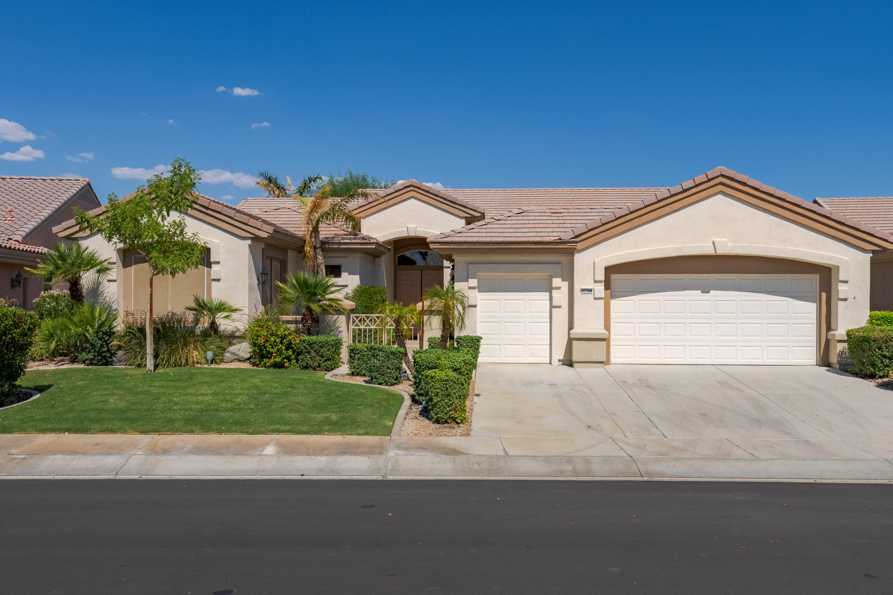 a front view of a house with a garden and plants